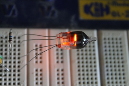 Figure 4 — A Z700U cold-cathode trigger tube on the bench. Unlike a plain neon, it has a third electrode — the trigger/starter — that fires the main anode-cathode gap on demand, below the gap's own self-strik…